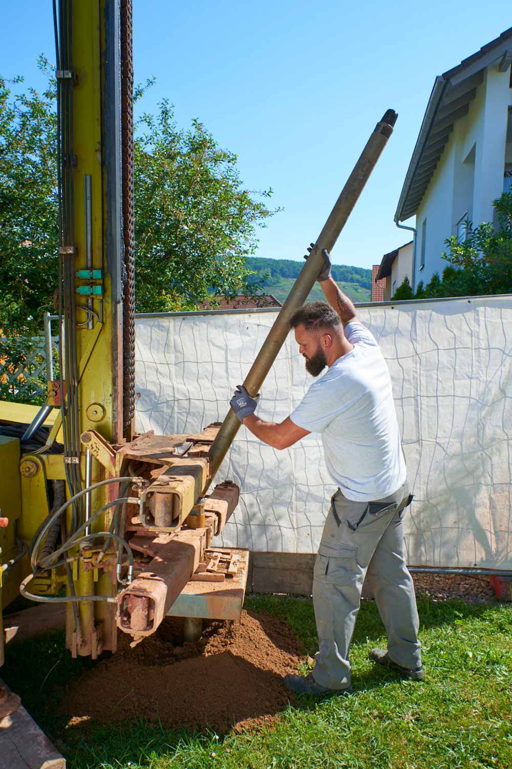 Bauarbeiter bereitet Bohrung im Garten vor